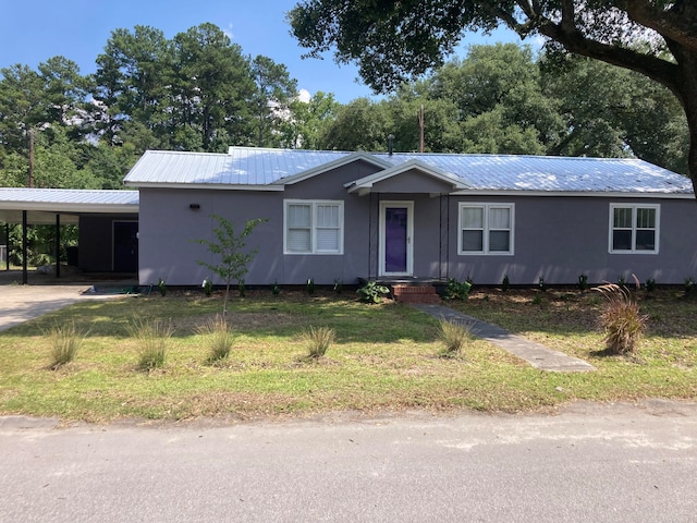 view of front facade with a front lawn and a carport