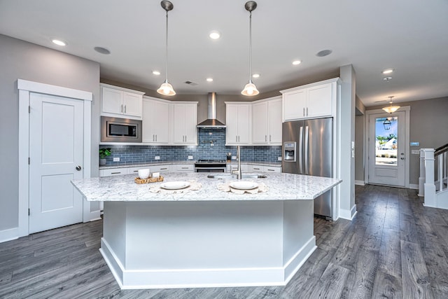 kitchen featuring appliances with stainless steel finishes, white cabinetry, and an island with sink