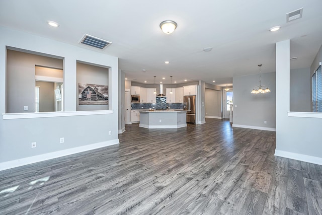 unfurnished living room with dark hardwood / wood-style flooring and a chandelier