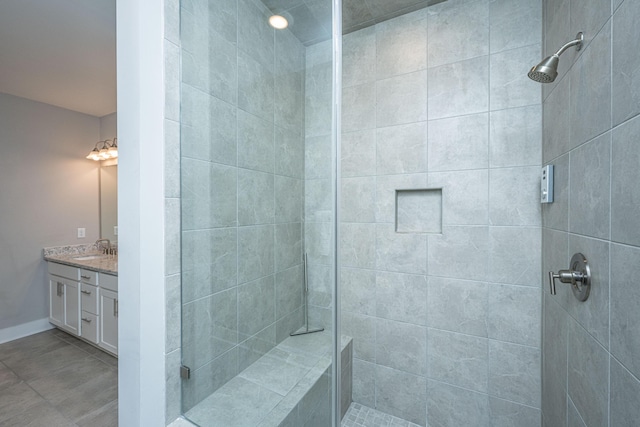 bathroom with a tile shower and vanity