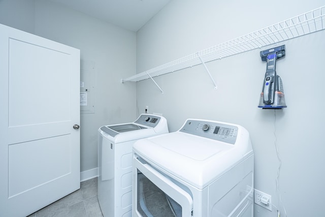 laundry area featuring washer and dryer, light tile patterned floors, and electric panel