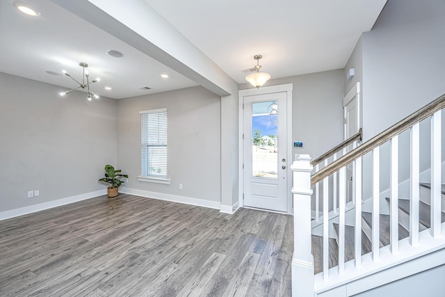 foyer with hardwood / wood-style floors, an inviting chandelier, and a wealth of natural light