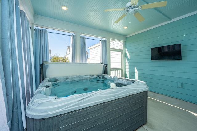 interior space with ceiling fan and a hot tub