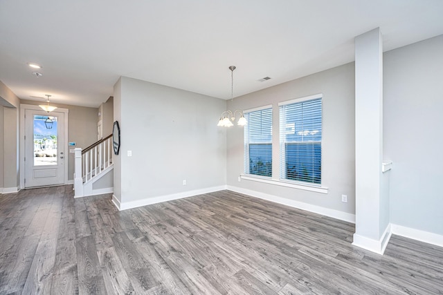 unfurnished room featuring a chandelier and wood-type flooring