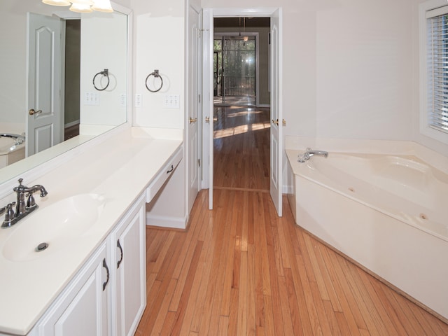 bathroom featuring hardwood / wood-style floors, vanity, and a bathing tub