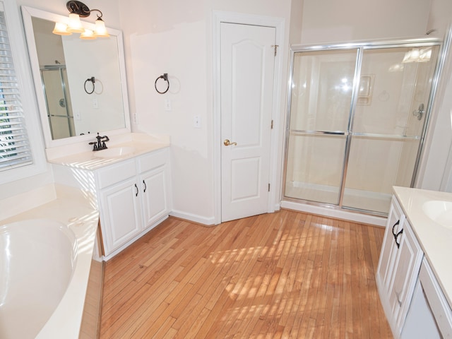 bathroom featuring a chandelier, shower with separate bathtub, vanity, and hardwood / wood-style flooring