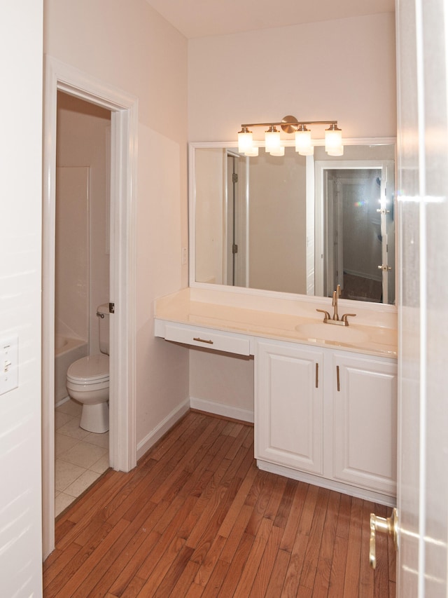 bathroom featuring toilet, vanity, and hardwood / wood-style flooring