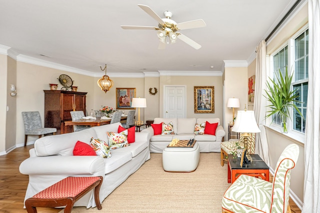 living room featuring baseboards, ornamental molding, ceiling fan, and wood finished floors