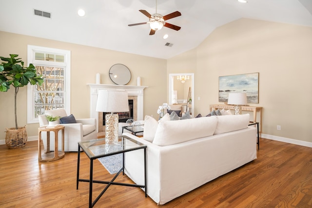 living room featuring lofted ceiling, ceiling fan, and wood-type flooring