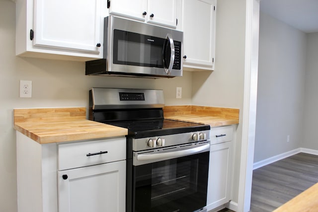 kitchen with white cabinets, stainless steel appliances, and hardwood / wood-style flooring