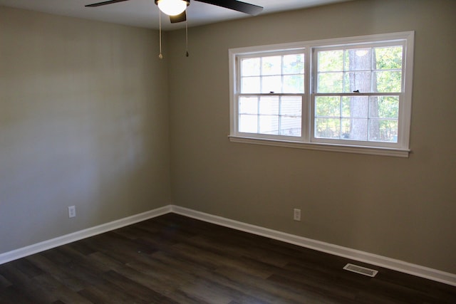 unfurnished room featuring ceiling fan, a healthy amount of sunlight, and dark wood-type flooring