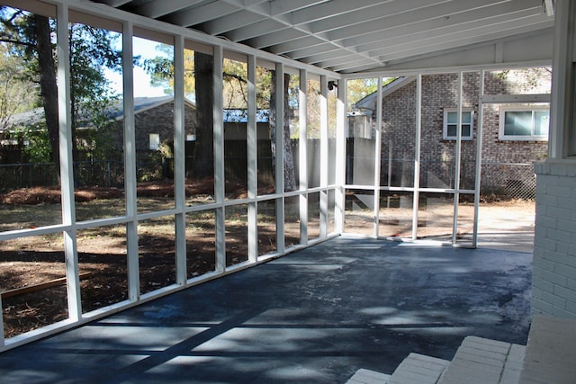 unfurnished sunroom with lofted ceiling