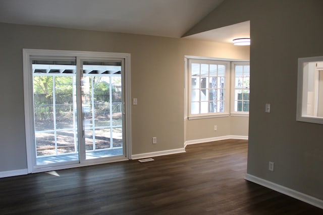 empty room with lofted ceiling and dark wood-type flooring