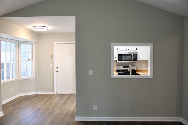 foyer with wood-type flooring and lofted ceiling