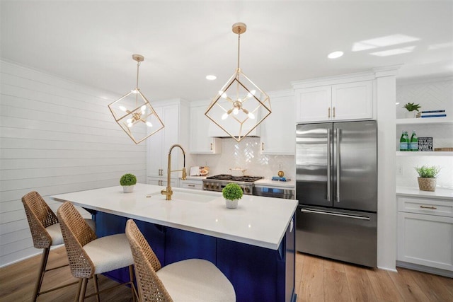 kitchen with high end refrigerator, pendant lighting, white cabinets, and light countertops