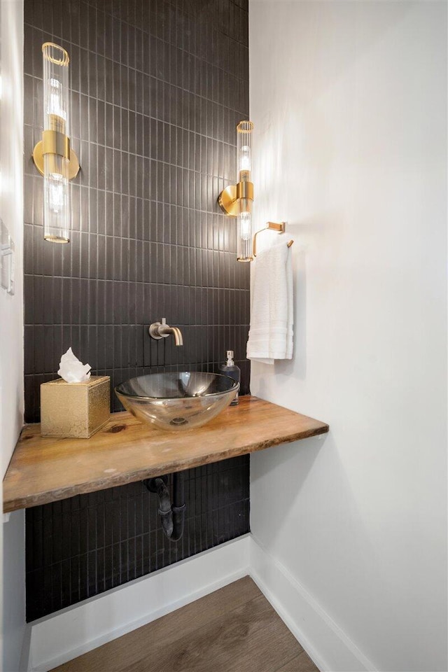 bathroom with a sink, baseboards, and wood finished floors