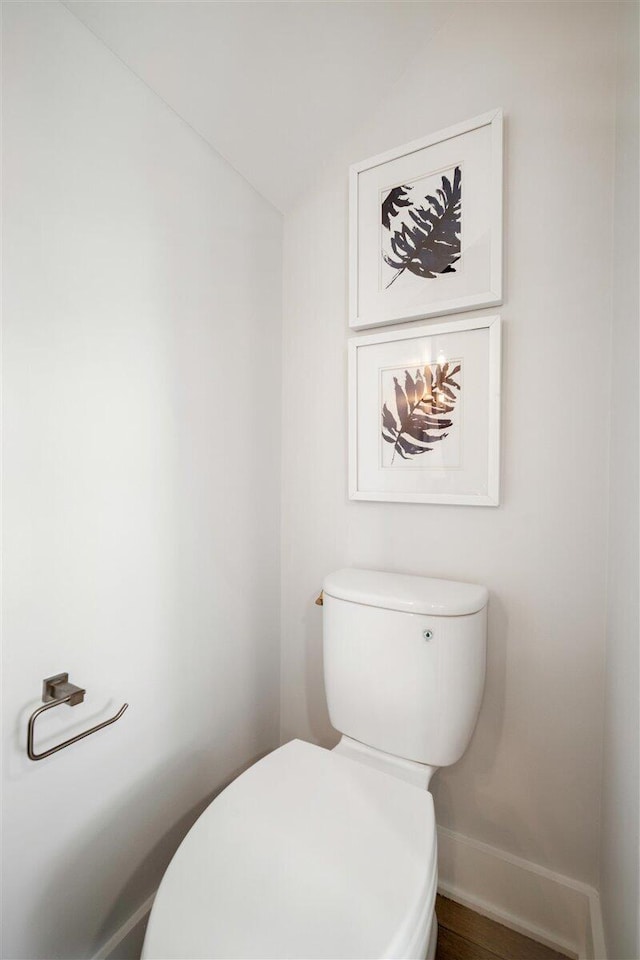 bathroom with toilet, baseboards, and lofted ceiling