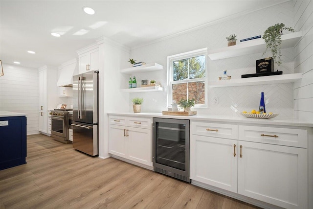 kitchen with white cabinets, wine cooler, high end appliances, and light countertops