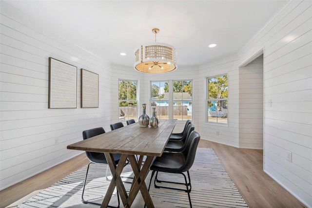 dining area featuring ornamental molding, plenty of natural light, a notable chandelier, and light wood finished floors