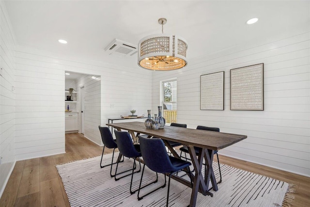 dining room featuring a chandelier, light wood-type flooring, recessed lighting, and a wall mounted AC