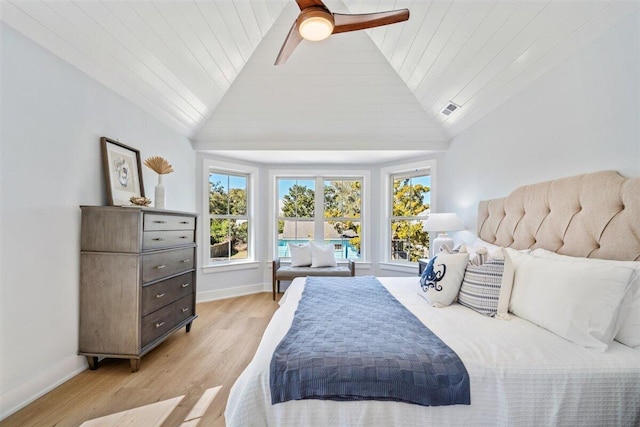 bedroom with light wood-style floors, lofted ceiling, visible vents, and baseboards