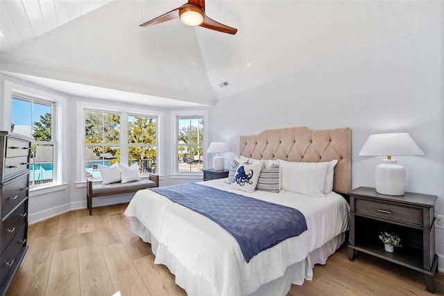 bedroom with ceiling fan, visible vents, baseboards, vaulted ceiling, and light wood finished floors