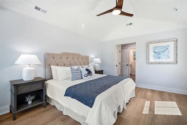 bedroom featuring vaulted ceiling, light wood finished floors, visible vents, and baseboards