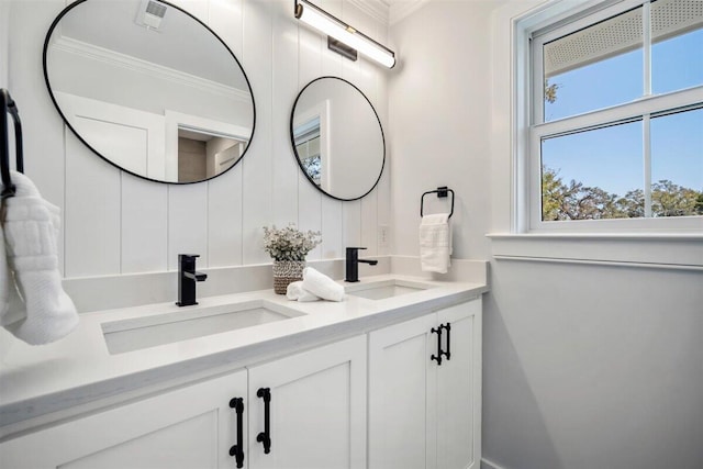 full bathroom featuring ornamental molding, visible vents, a sink, and double vanity