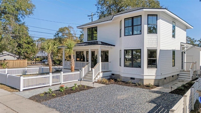 view of front of property with metal roof, a fenced front yard, roof with shingles, crawl space, and a standing seam roof