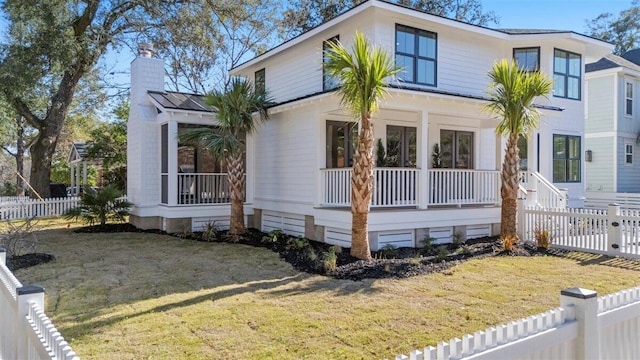 view of front facade featuring a porch, a front yard, and fence private yard