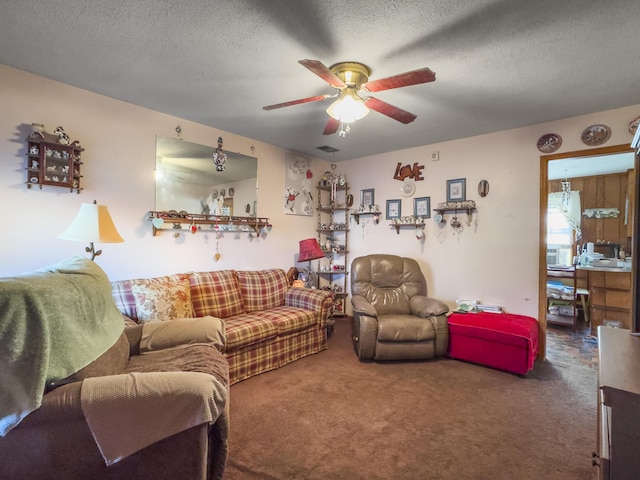 carpeted living room with a textured ceiling and ceiling fan