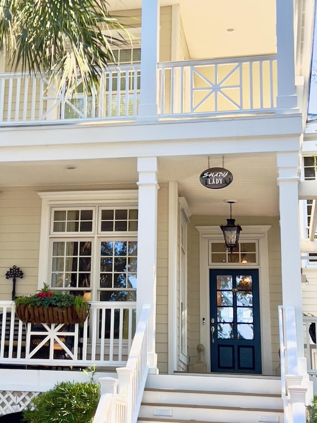 doorway to property featuring a balcony and a porch