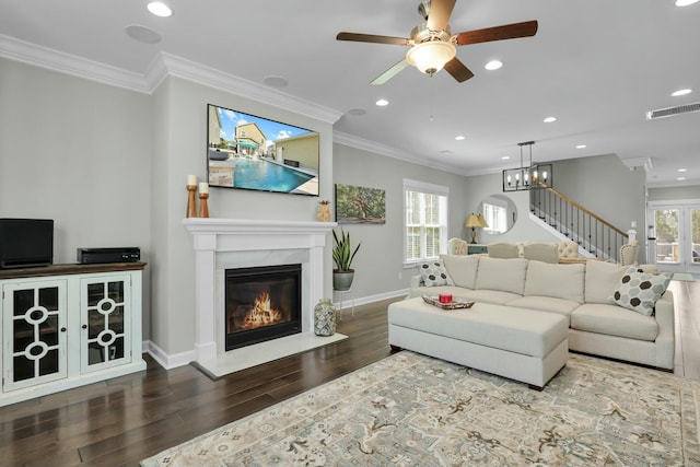 living room featuring visible vents, a healthy amount of sunlight, wood finished floors, and ornamental molding