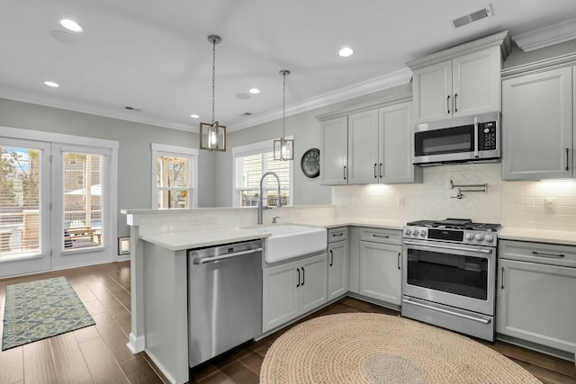 kitchen featuring visible vents, appliances with stainless steel finishes, light countertops, and a sink