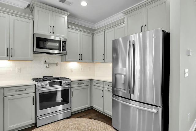 kitchen featuring visible vents, light countertops, dark wood-type flooring, appliances with stainless steel finishes, and tasteful backsplash