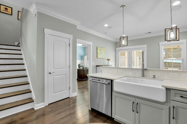 kitchen with crown molding, light countertops, stainless steel dishwasher, dark wood-style floors, and a sink