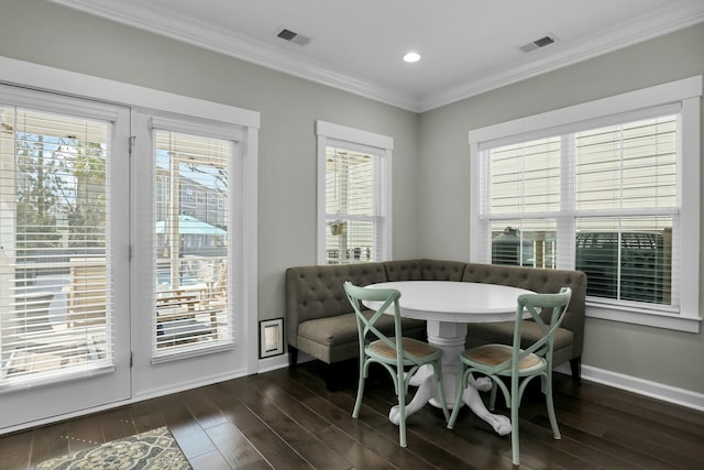 dining area with visible vents, baseboards, dark wood finished floors, and crown molding