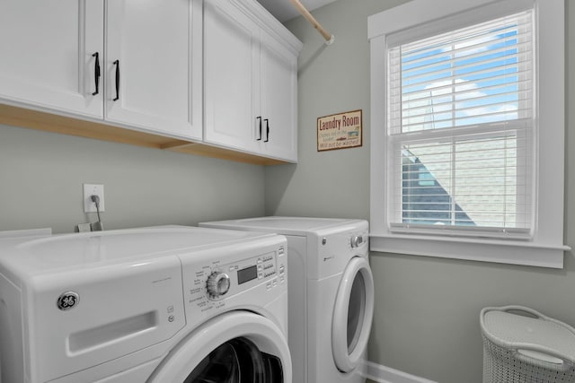 clothes washing area featuring cabinet space, washing machine and dryer, and a wealth of natural light