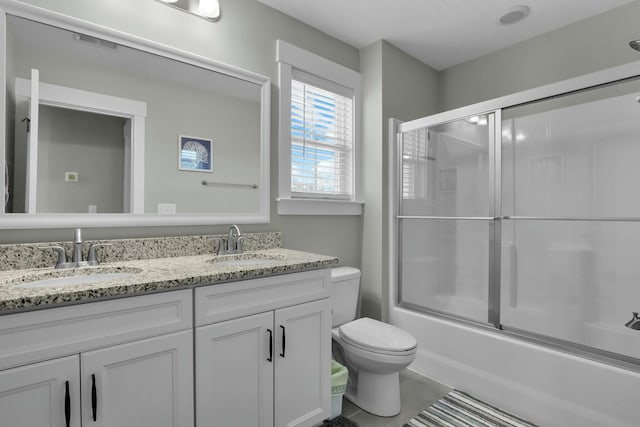 full bath with double vanity, visible vents, toilet, and a sink