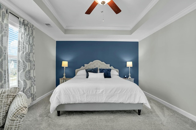 bedroom with a raised ceiling, visible vents, and carpet floors