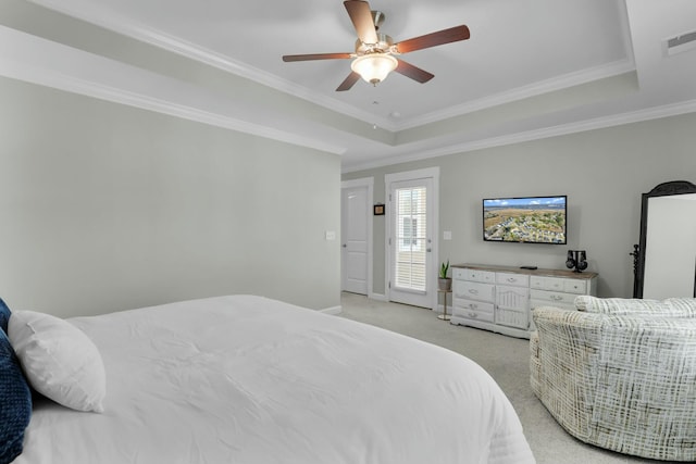 bedroom featuring a tray ceiling, light colored carpet, visible vents, and ornamental molding