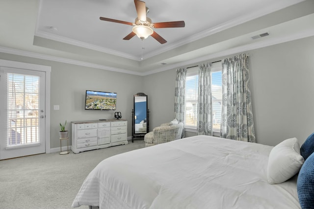 carpeted bedroom featuring visible vents, a raised ceiling, ornamental molding, and a ceiling fan