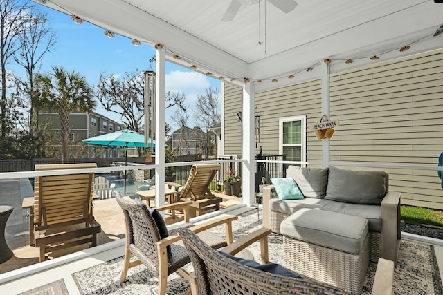 wooden terrace with a fenced backyard, a swimming pool, an outdoor hangout area, and a ceiling fan