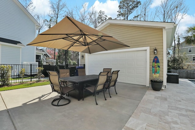 view of patio / terrace featuring driveway, outdoor dining area, a garage, and fence