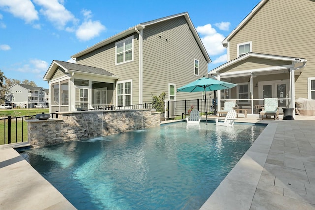 back of property featuring a fenced in pool, fence, french doors, a sunroom, and a patio