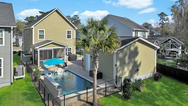 back of house with a fenced in pool, a lawn, a fenced backyard, a sunroom, and a patio