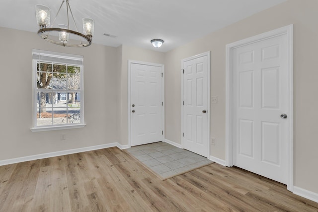 foyer entrance featuring an inviting chandelier and light hardwood / wood-style flooring