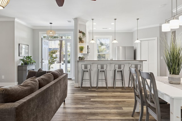 dining area featuring ornamental molding, ceiling fan, and wood-type flooring