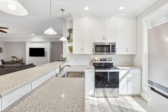 kitchen featuring white cabinets, appliances with stainless steel finishes, and pendant lighting