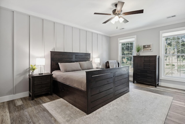 bedroom with ornamental molding, ceiling fan, and wood-type flooring